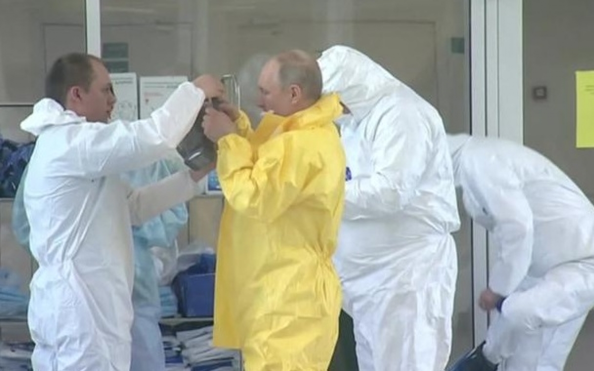 Tổng thống Nga Putin (áo vàng) mặc đồ bảo hộ. Ảnh: CNN.